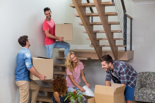 Professional furniture movers handling a sofa in Fulham