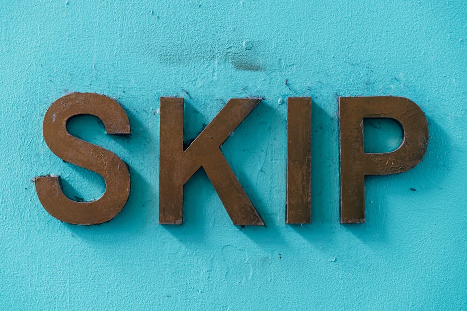 A rectangular metal sign with black background and white lettering affixed to a weathered brick wall, reading 'NO BUSKING OUTSIDE THESE PREMISES' in capital letters. The sign is attached with visible